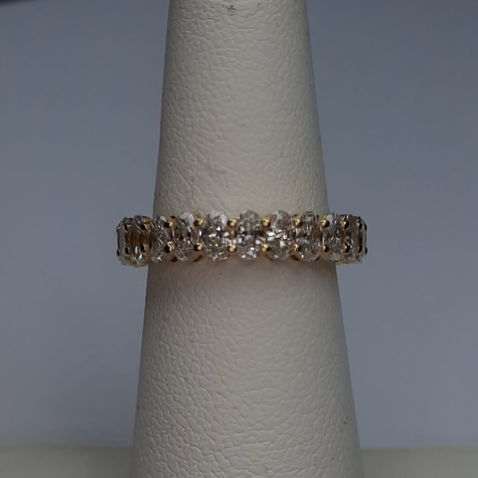 Original photograph of the oval diamond eternity band on a ring stand.